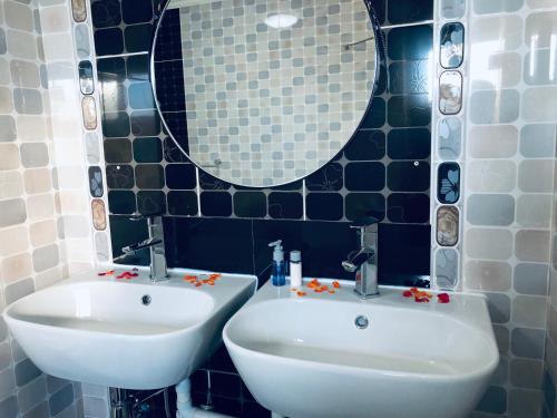 a bathroom with a white sink and a mirror at Gabz Airport Inn in Gaborone