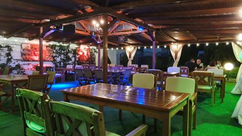 a restaurant with wooden tables and chairs and people in the background at Hotel Garden Club in Braşov