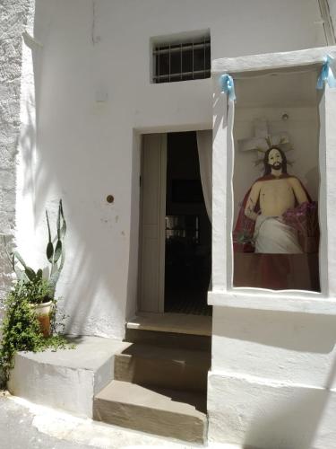 a man wearing a mask in a white building at Mèna Mè - Casa vacanza - Salento in Parabita
