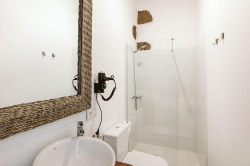 
a bathroom with a toilet, sink, and shower at Hotelito Rural Flor de Timanfaya in Tinajo
