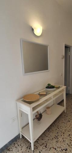 einen weißen Tisch mit einem Spiegel an der Wand in der Unterkunft Casa Lucky in Grosseto