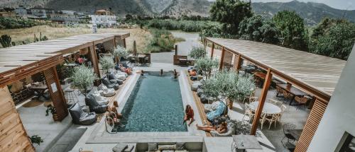 an overhead view of a pool with people sitting around it at Ikaros Suites in Amoudara Herakliou