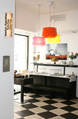 a room with a table and some pendant lights at Chelsea Hotel in Cologne