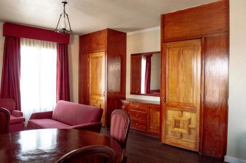 a living room with a table and a chair and a window at Best Western Majestic in Mexico City