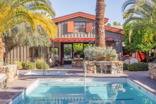 uma casa com uma piscina e uma palmeira em Sparrows Lodge em Palm Springs