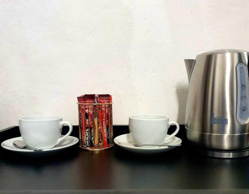 two coffee cups and a can on a table at XG Guesthouse in Barkly East