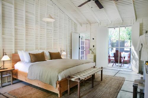 a bedroom with a large bed and a bench at Sparrows Lodge in Palm Springs