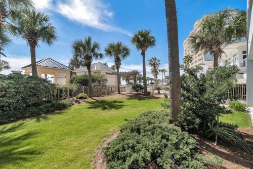 ein Hof mit Palmen vor einem Haus in der Unterkunft Bristol 109 - Lovely Ground Floor Beachfront Unit in Gulf Shores
