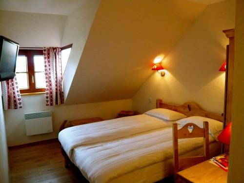 a bedroom with a large bed in a attic at The Originals Boutique, Hôtel La Ferme du Pape, Eguisheim in Eguisheim