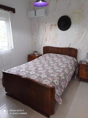 a bedroom with a bed with a floral bedspread at To nisaki(το νησακι) in Asklipiḯon