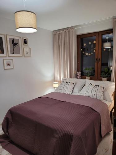 sypialnia z dużym łóżkiem i fioletowym kocem w obiekcie Apartament Anna w Ustce