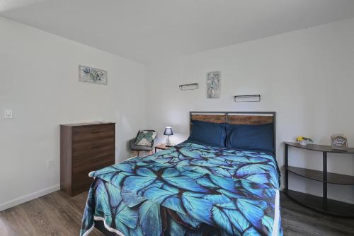 a bedroom with a bed with a blue comforter at Brownsville Motel in Brownsville