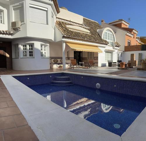 a house with a swimming pool in front of a house at Villa Casa Vega Fuengirola in Fuengirola