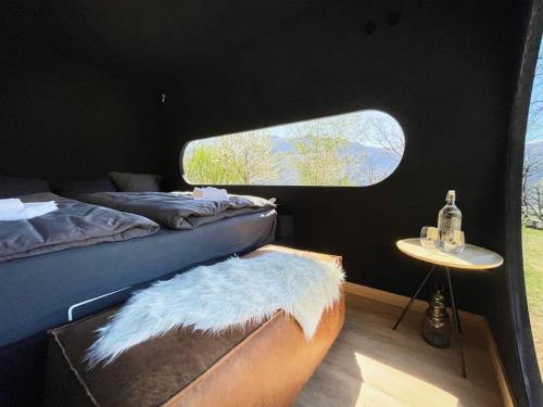 Zimmer mit 2 Betten und einem Tisch mit Fenster in der Unterkunft Birdbox Curzútt in Monte Carasso