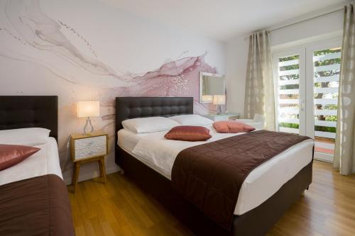 1 dormitorio con 2 camas y ventana en Apartments Zicara, en Dubrovnik