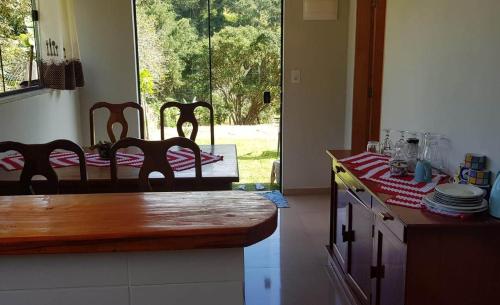 uma cozinha com uma mesa com uma toalha de mesa vermelha e branca em Chalé no campo à caminho de Monte Verde em Camanducaia