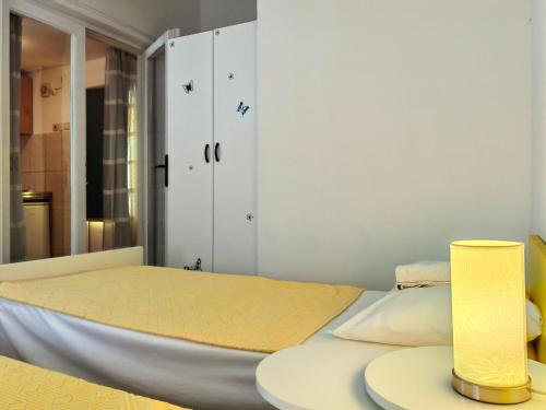 1 dormitorio con 1 cama y 1 lámpara en una mesa en Apartmani Abeona, en Budva