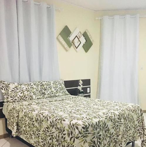a bedroom with a bed with a black and white blanket at Hotel União in Pojuca