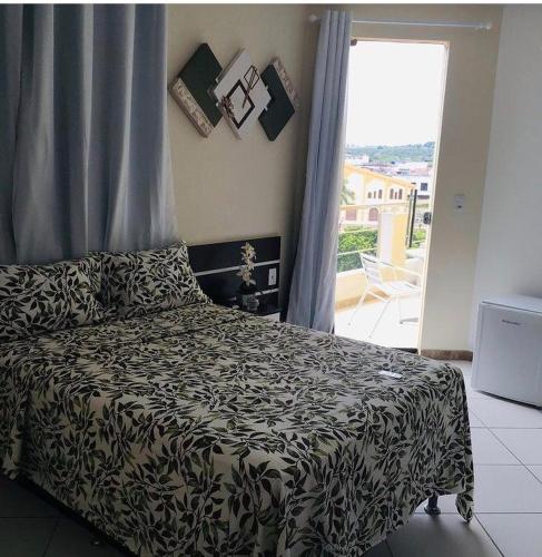 a bedroom with a bed with a black and white blanket at Hotel União in Pojuca