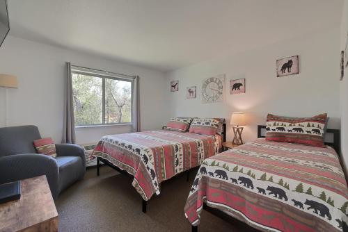 a bedroom with two beds and a chair and a window at Brownsville Motel in Brownsville