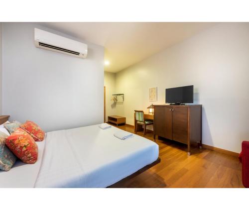 a bedroom with a bed and a desk with a television at Dinso Home Boutique in Bangkok