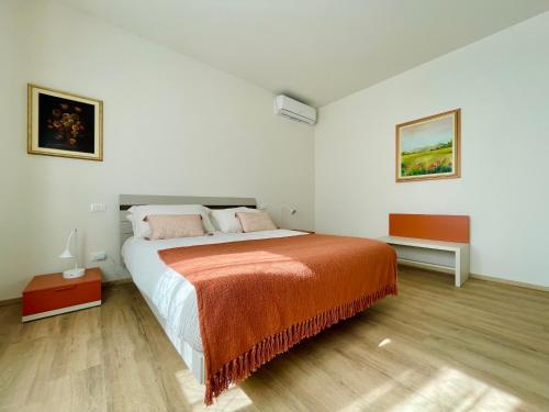 a bedroom with a large bed with an orange blanket at Appartamento i Limori in San Giuliano Terme