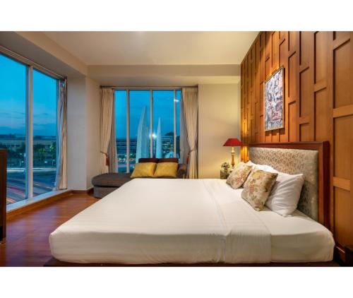 a bedroom with a large bed with a large window at Dinso Home Boutique in Bangkok