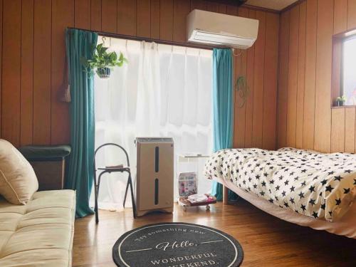 横浜市にあるYokohama HY Housmd - Vacation STAY 03600vのベッド1台、ソファ、窓が備わる客室です。