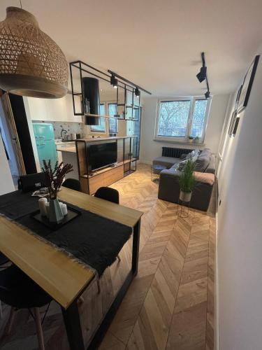 a living room with a dining table and a kitchen at Apartament Giżycko in Giżycko