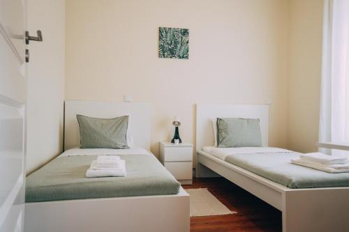 um quarto com 2 camas e lençóis verdes em Green Coast Surf House em Espinho