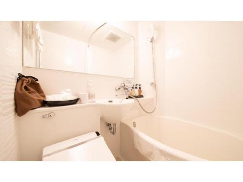 ein Badezimmer mit einer Badewanne, einem WC und einem Waschbecken in der Unterkunft Kamon Hotel Namba - Vacation STAY 37041v in Osaka