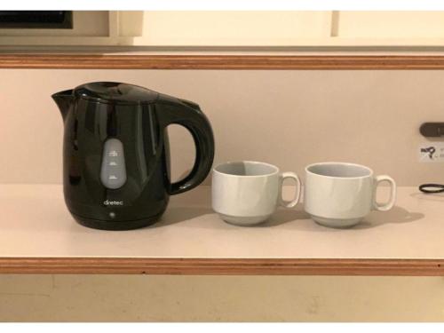 a coffee pot and two cups on a counter at Kamon Hotel Namba - Vacation STAY 37041v in Osaka