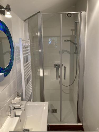 a bathroom with a glass shower and a sink at LE CHALET de LA LONGERE in Beuvry-Nord