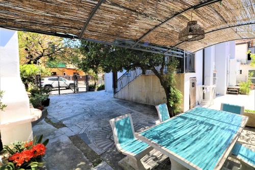 eine Terrasse mit einem Tisch und Stühlen unter einer Pergola in der Unterkunft Giglio di Mare in Ascea
