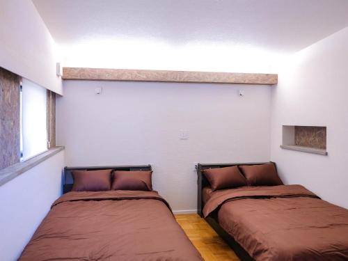 2 camas en una habitación con paredes blancas en Forest Villa Nanso no Oka - Vacation STAY 39402v, en Minamiboso