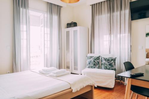 a bedroom with a bed and a desk and a window at Green Coast Surf House in Espinho