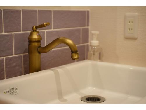 a sink with a gold faucet in a bathroom at Expected Inn - Vacation STAY 41403v in Fukuoka