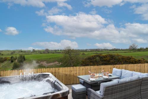 a hot tub on a patio with a table and chairs at The Hideaway @ Watergate eye Farm in Barnard Castle