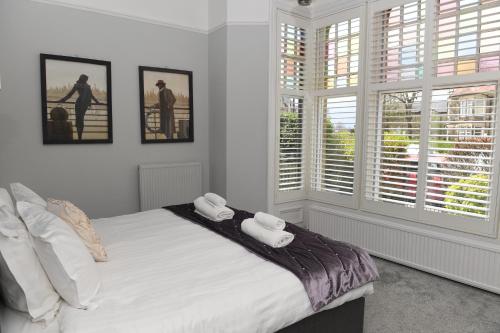 a bedroom with a bed with two towels on it at Courtyard Mews - 2 large en suite bedrooms, Garden - Harrogate Holiday Apartments in Harrogate