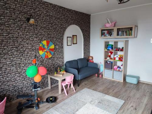 a living room with a blue couch and a brick wall at Willa Orle Gniazdo in Biały Kościół