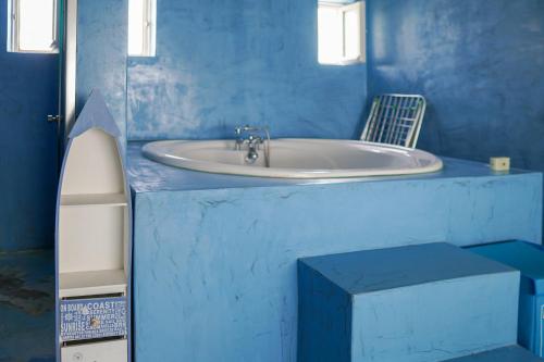 a blue bathroom with a sink and a chair at Boathouse in Kardamaina