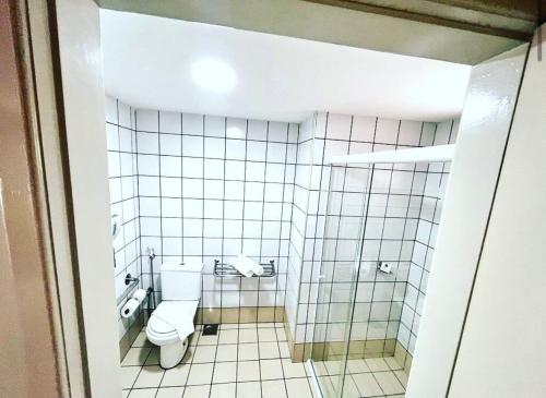 Un baño con inodoro y una pared de azulejos. en Apê Beira Mar Meireles Com café da manhã, en Fortaleza