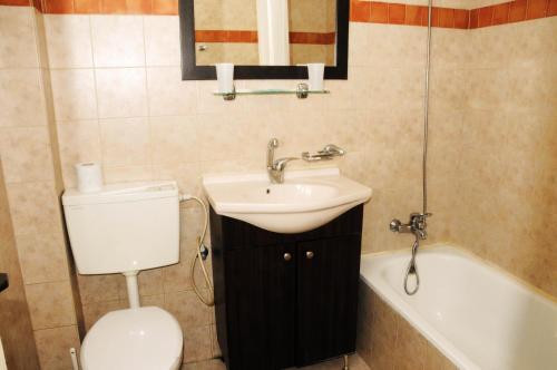 a bathroom with a toilet and a sink and a bath tub at The Little House In Bakah in Jerusalem