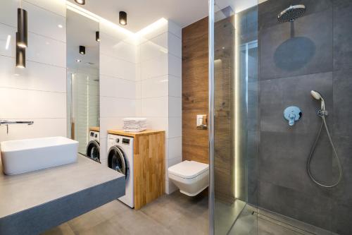 a bathroom with a washing machine and a toilet at Apartamenty Usteckie Wydma in Ustka