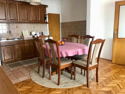 eine Küche mit einem Tisch und einem rosa Tischtuch in der Unterkunft Apartmani RADA in Trebinje