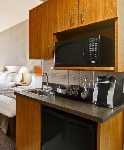 a kitchen with a microwave and a sink in a hotel room at Canalta Brooks in Brooks