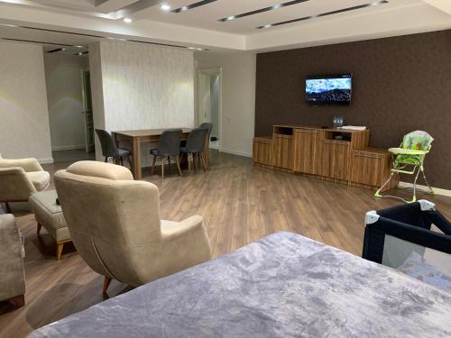 - une salle d'attente avec des chaises et une télévision murale dans l'établissement Park Azure Apartment Deluxe 2 Bedroom, à Baku