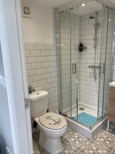 a bathroom with a toilet and a glass shower at Lytham Sea Salt Lodge in Lytham St Annes