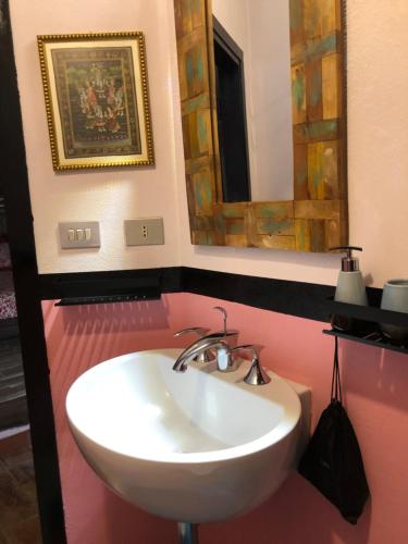 ein Badezimmer mit einem weißen Waschbecken und einem Spiegel in der Unterkunft L'antico Molino in Lubriano