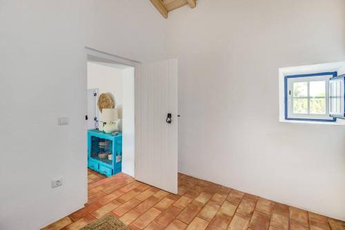an empty room with a door and a wooden floor at Monte Alentejano - Melides in Melides